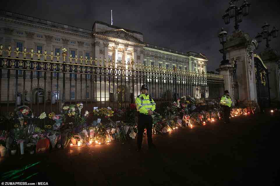 Candles lit up the flowers laid by thousands of people in London tonight at Buckingham Palace