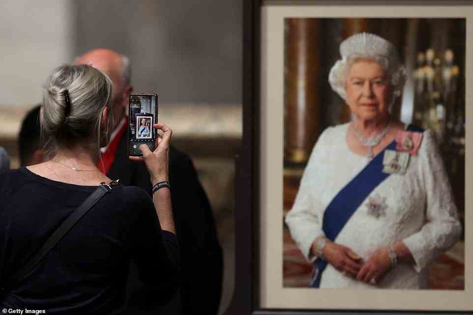 A woman takes a picture after participating in a service of prayer and reflection, following the passing of Queen Elizabeth II