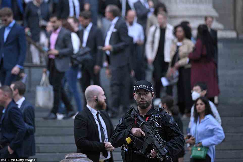 An armed police officer stands guard as people leave a Service of Prayer and Reflection for Britain's Queen Elizabeth II at St Paul's Cathedral