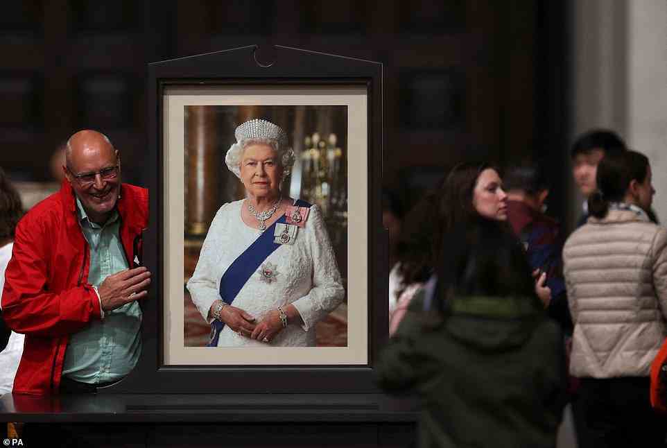 A man poses next to a picture of Queen Elizabeth II after the Service of Prayer and Reflection at St Paul's Cathedral