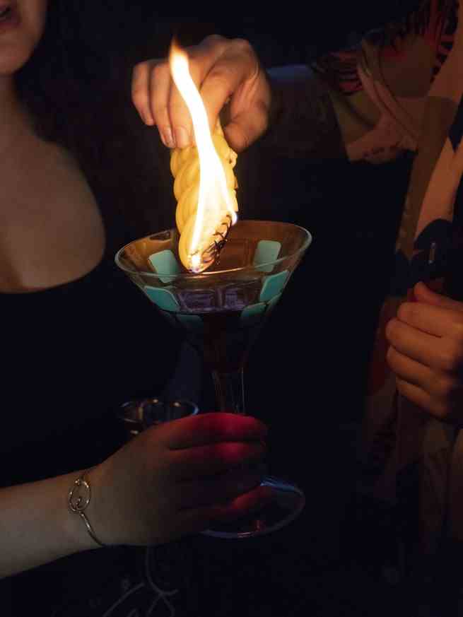 eine Kerze in einem Weinglas löschen