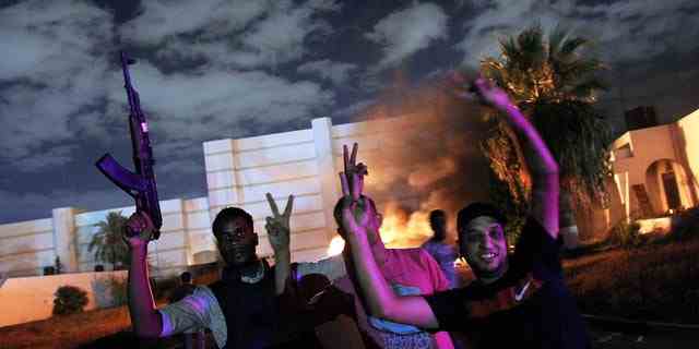 Demonstranten zwangen am 21. September 2012 Mitglieder der islamistischen Hardline-Gruppe Ansar el-Sharia aus ihrem Stützpunkt in Bengasi, Libyen.  Der Mob zündete auf dem Gelände mindestens ein Fahrzeug an.