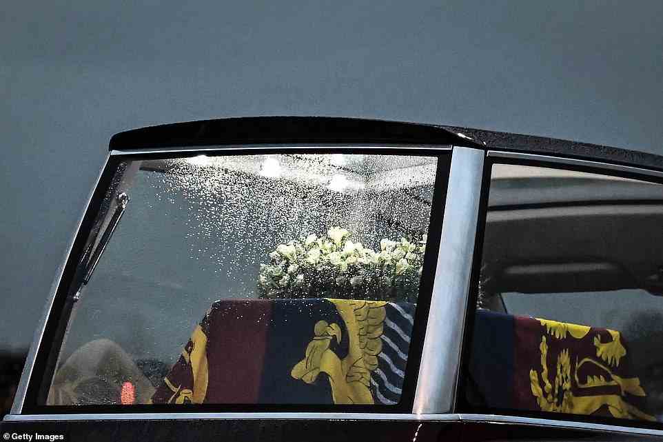 Raindrops run down the window of the Royal Hearse as it departs