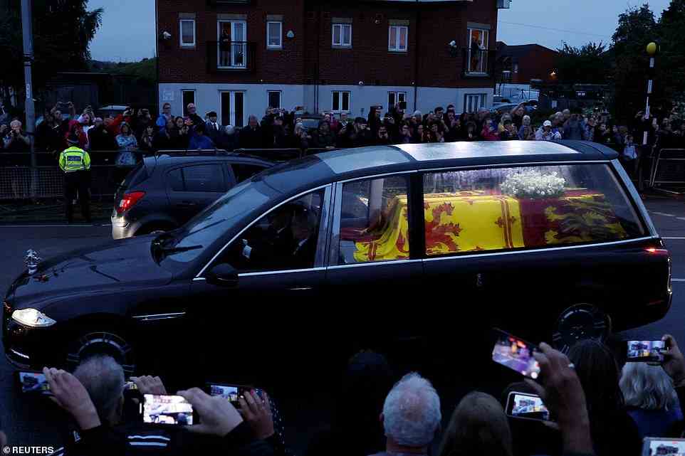 People watch the hearse carrying the coffin of Queen Elizabeth, following her death, after leaving RAF Northolt