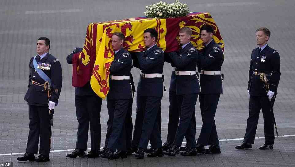 The coffin of Queen Elizabeth II is carried off a plane by the Queen's Colour Squadron at RAF Northolt