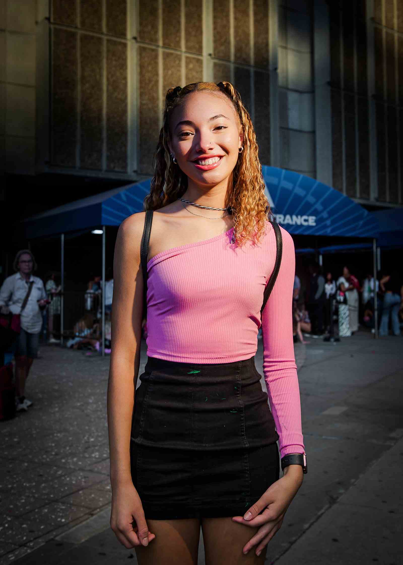 Eine Person, die ein rosa Hemd und einen schwarzen Rock vor dem Madison Square Garden trägt.