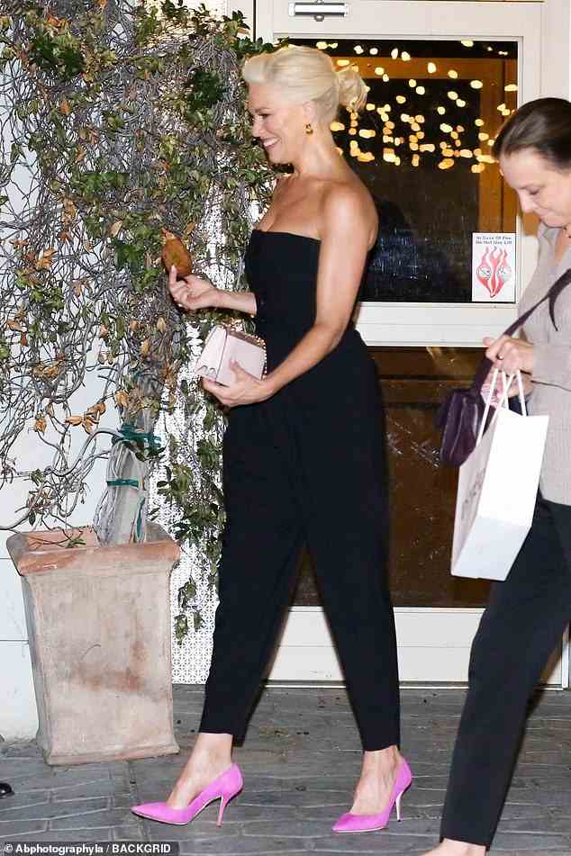 Stunner: Die britische Schauspielerin ergänzte ihren Look mit hellrosa Wildleder-Heels und einer weißen Clutch-Tasche, als sie in einen frechen Keks steckte