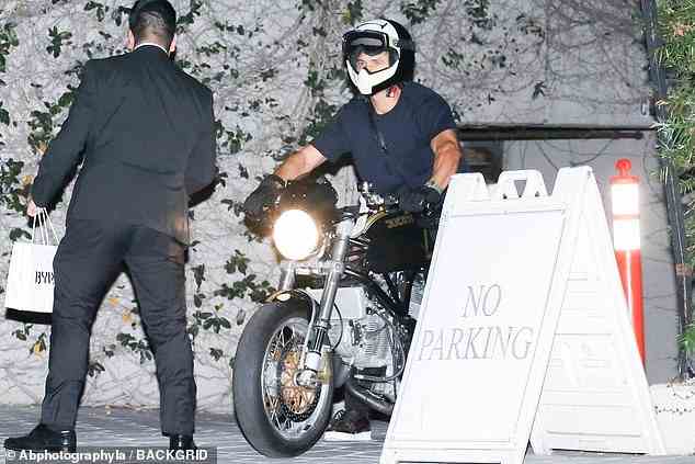 Wiedersehen!  Er verabschiedete sich vom Hotelpersonal, als er auf der Rückseite seines Motorrads davonfuhr