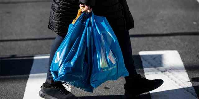 Ein Käufer trägt Plastiktüten im New Yorker Stadtteil Manhattan am 1. März 2020.