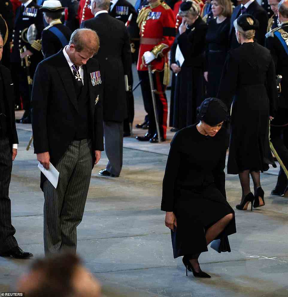 Meghan was seen dipping a low curtsey in front of the Queen's coffin this afternoon (pictured) while Prince Harry bowed his head