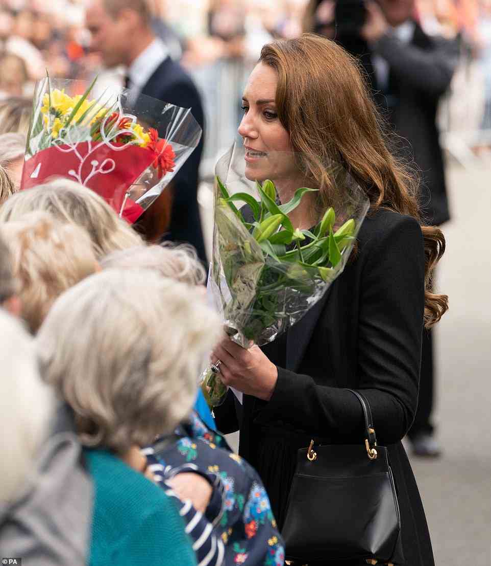 Kate chats to members of the public as she receives several bouquets