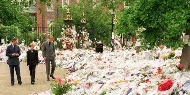Prinz William und Prinz Harry betrachten die Blumen, die Tausende von Trauernden nach dem Tod von Prinzessin Diana im Jahr 1997 hinterlassen haben.