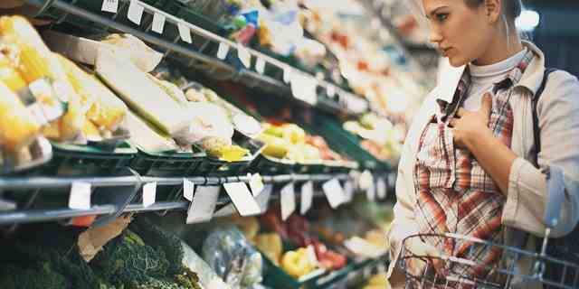 Eine Frau kauft Lebensmittel im Laden ein.  Lebensmitteletiketten sorgfältig lesen, sagen Gesundheitsexperten und Ernährungswissenschaftler. 