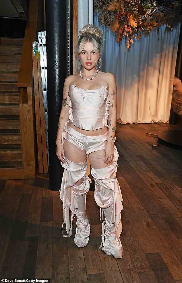 Heiße Sachen: Das 24-jährige Model setzte ihren Look mit zerrissenen weißen Spitzenstrümpfen fort, die sie unter einer Seidenhose trug (im Bild mit der Designerin Elisa Trombatore)