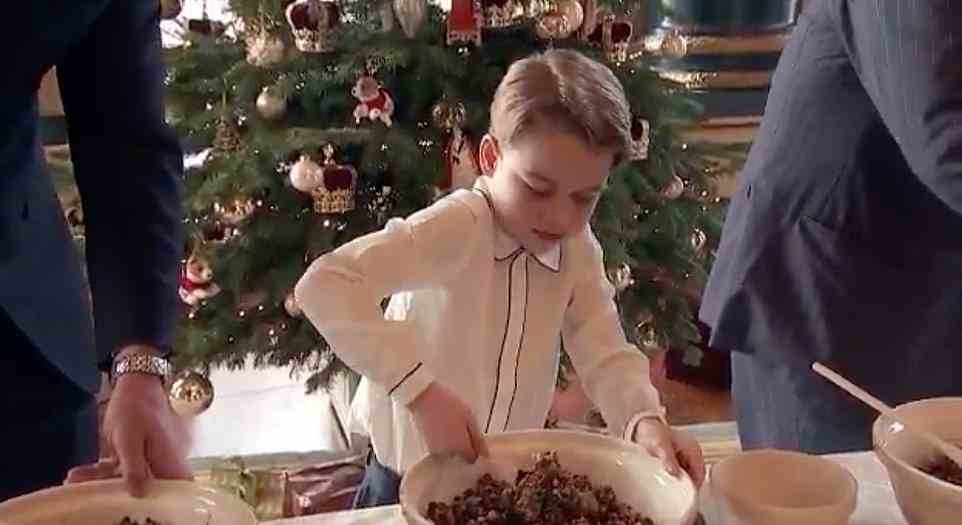 Prince George, dressed in a white shirt with black piping and a cute collar, tries very hard to mix the pudding