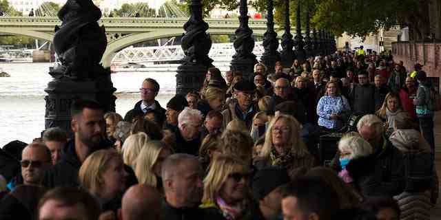 Menschen warten in einer Warteschlange gegenüber dem Westminster Palace, um der verstorbenen Königin Elizabeth II. ihren Respekt zu erweisen, während ihr Sarg am Freitag, den 16. September 2022 in der Westminster Hall, London, aufgebahrt ist. 
