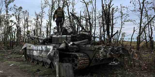 TOPSHOT – Dieses am 11. September 2022 aufgenommene Foto zeigt einen ukrainischen Soldaten, der auf einem verlassenen russischen Panzer in der Nähe eines Dorfes am Stadtrand von Izyum, Region Charkiw, steht.