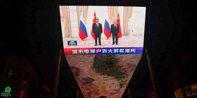 Ein riesiger Bildschirm überträgt Nachrichtenaufnahmen des chinesischen Präsidenten Xi Jinping und des russischen Präsidenten Wladimir Putin, die während eines Treffens am Rande des Gipfeltreffens der Shanghai Cooperation Organization (SCO) in Usbekistan in Peking, China, am 16. September 2022 für Fotos posieren. 
