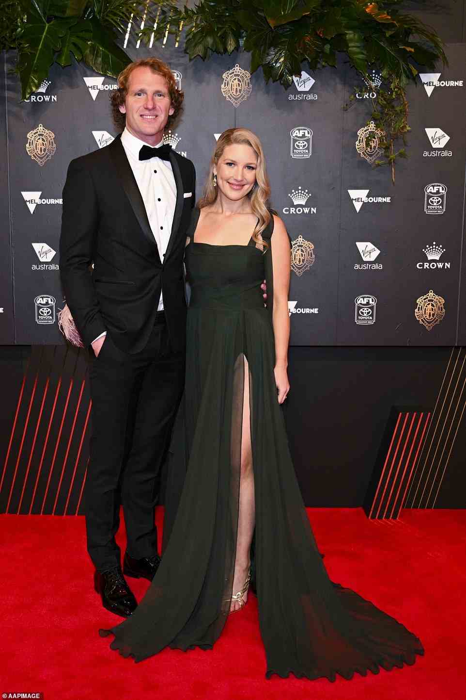 David Mundy of Fremantle Dockers with partner Sally Mundy looked handsome together, although Sally almost suffered a wardrobe malfunction when the split in her dress showed her bodysuit underneath