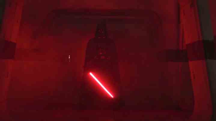Darth Vader zündet sein Lichtschwert und beleuchtet die Halle in Rogue One rot.