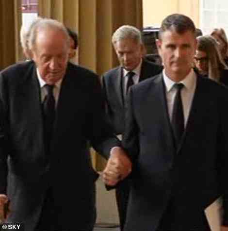 Former King Juan Carlos is supported as he arrives at the palace