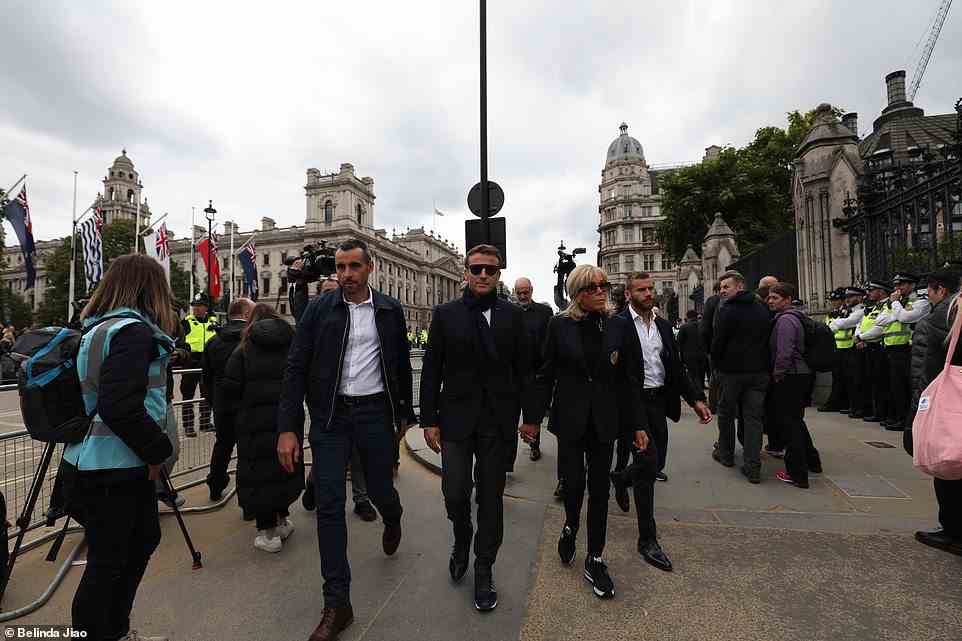 The Macrons were seen donning sunglasses as they strolled through central London today, flanked by aides and security guards