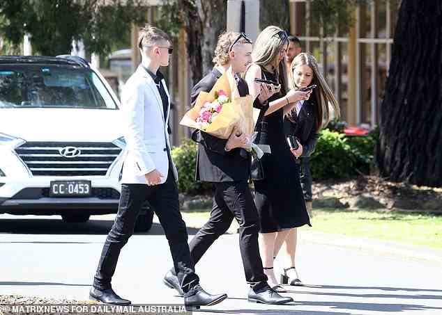 Eine Gruppe Teenager, darunter einer mit Blumen, macht sich am Montag auf den Weg zum Gottesdienst in Leppington