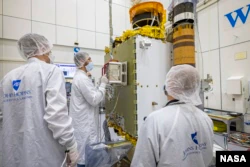 Mitglieder des DART-Teams vom Johns Hopkins Applied Physics Laboratory in Maryland und der Italian Space Agency positionieren den LICIACube sorgfältig auf dem DART-Raumschiff.  (Bildnachweis: NASA/Johns Hopkins APL/Ed Whitman)