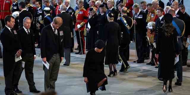 Meghan Markle macht einen Knicks, als sie Königin Elizabeth II. ihren Respekt erweist.