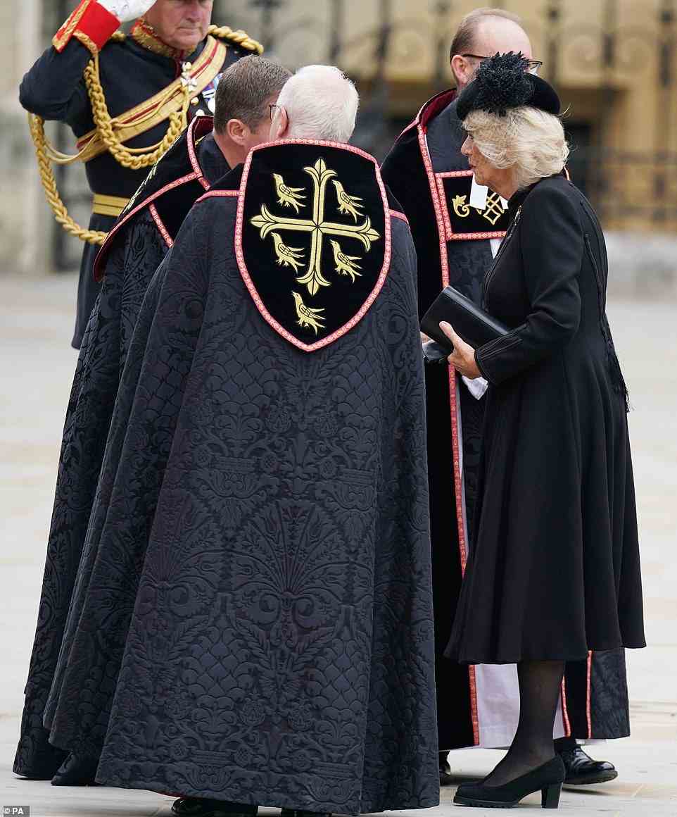 Camilla, who was wearing a black coat dress, spoke a moment with members of the church grouped outside, ahead of the funeral