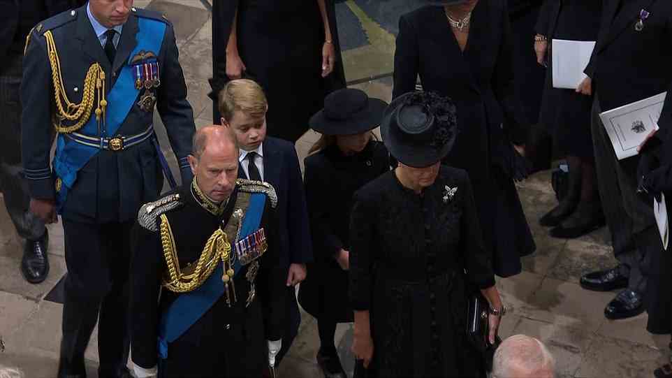 Edward, the Earl of Wessex, walks to his seat next to his wife Sophie, as Prince William follows with his eldest son Prince George