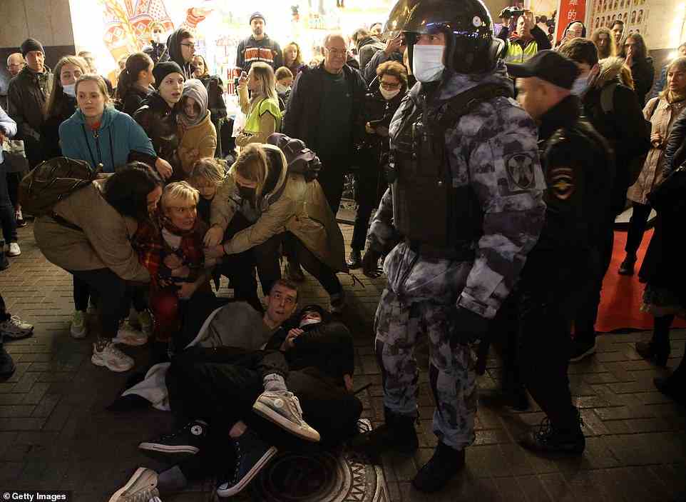 A Russian police officer tries to detain a protester in Moscow tonight. Reports indicate that more than 800 people have been arrested by security forces in the country so far