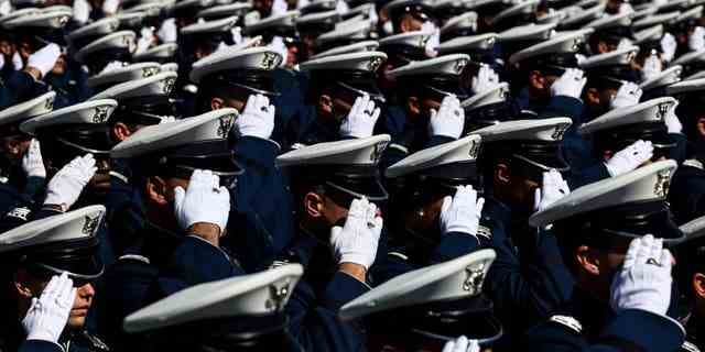 Kadetten der Air Force Academy grüßen während der Nationalhymne im Falcon Stadium für ihre Abschlussfeier am 25. Mai 2022 in Colorado Springs, Colorado.