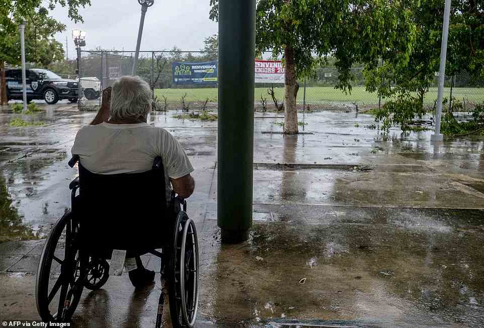 A man in Wheelchair looks at a flooded road after the passage of hurricane Fiona in Salinas, Puerto Rico