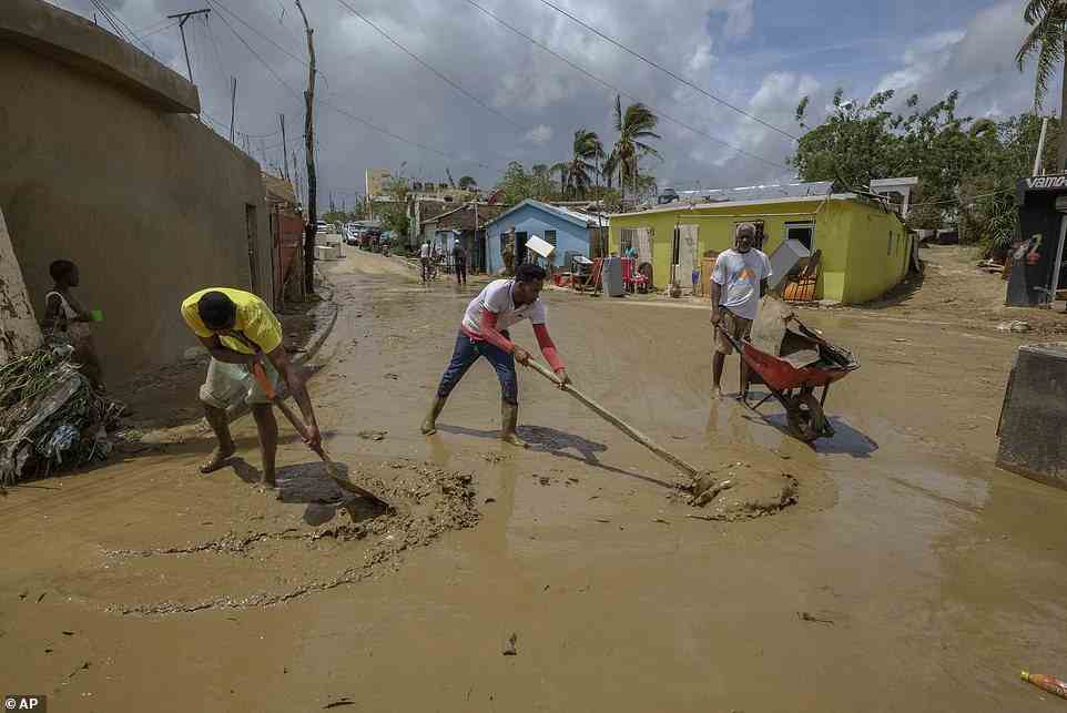 Locals clear mud brought by Hurricane Fiona in the Los Sotos neighborhood of Higuey, Dominican Republic