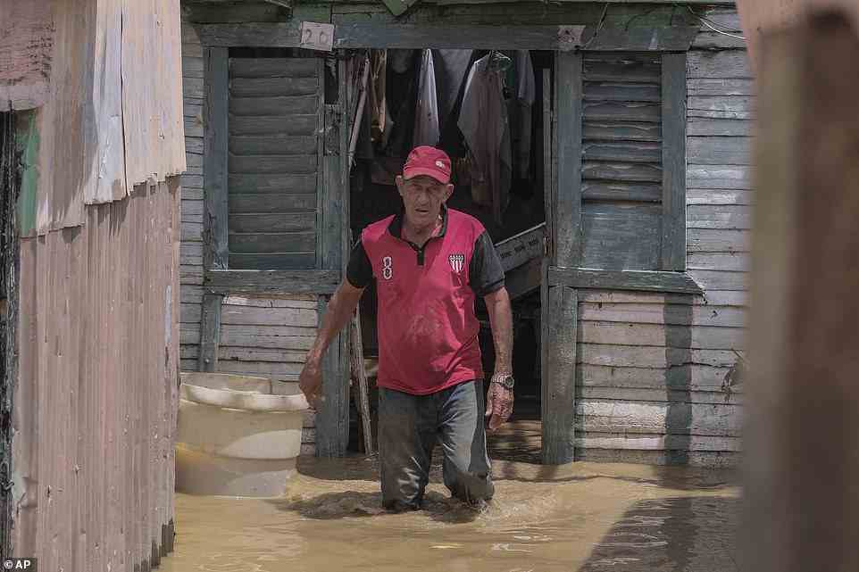 Nicasio Gil walks through the stagnant water left by the swollen Duey river after the passing of Hurricane Fiona in the Los Sotos neighborhood of Higuey