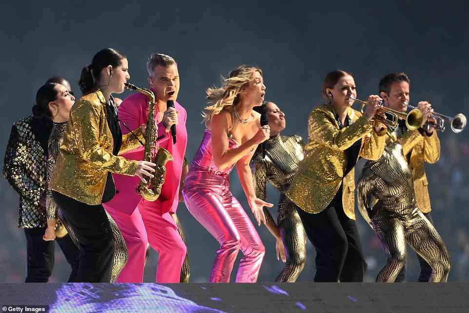 Williams (im Bild mit Delta Goodrem) war umgeben von Background-Tänzern in hautengen goldenen Bodysuits und silbernen Raumanzügen sowie einer Live-Band