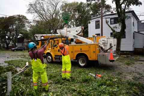 Arbeiter heben am Samstag in Halifax ein umgestürztes Kabel, um Maschinen den Zugang zu umgestürzten Bäumen zu ermöglichen.