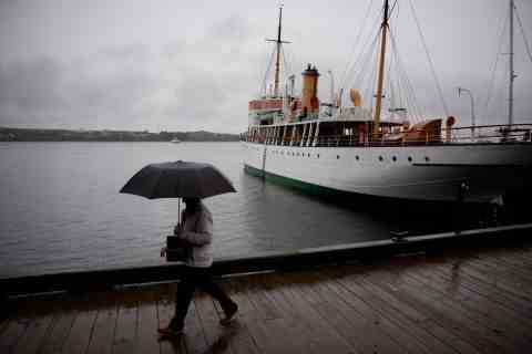 Ein Fußgänger schützt sich am Freitag mit einem Regenschirm, als er am Ufer von Halifax entlang geht.