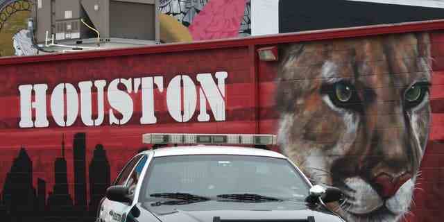 Ein Polizeiauto aus Houston vor einem mit Graffiti bedeckten Gebäude im Stadtteil Old Chinatown in der Nähe des George R. Brown Convention Center.