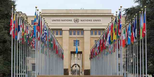 Genf, Schweiz - 17. Dezember 2017: Allee des Nations (Allee der Nationen) des Palastes der Vereinten Nationen in Genf, mit den Flaggen der Mitgliedsländer.