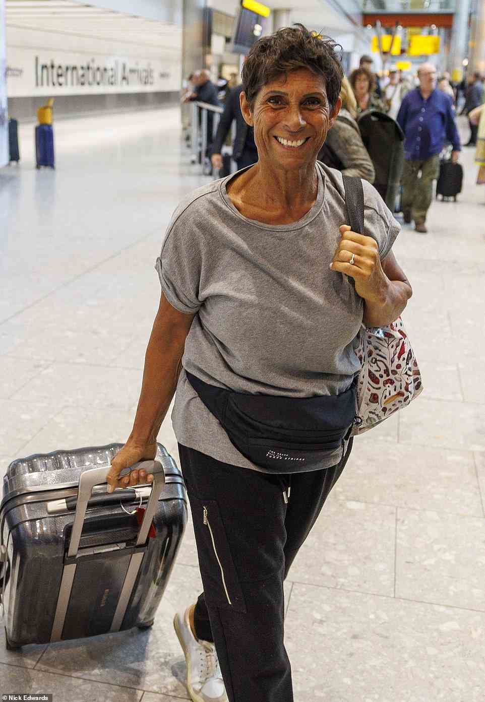 Happy! Fatima was all smiles in a T-shirt as she wheeled her bags through the airport