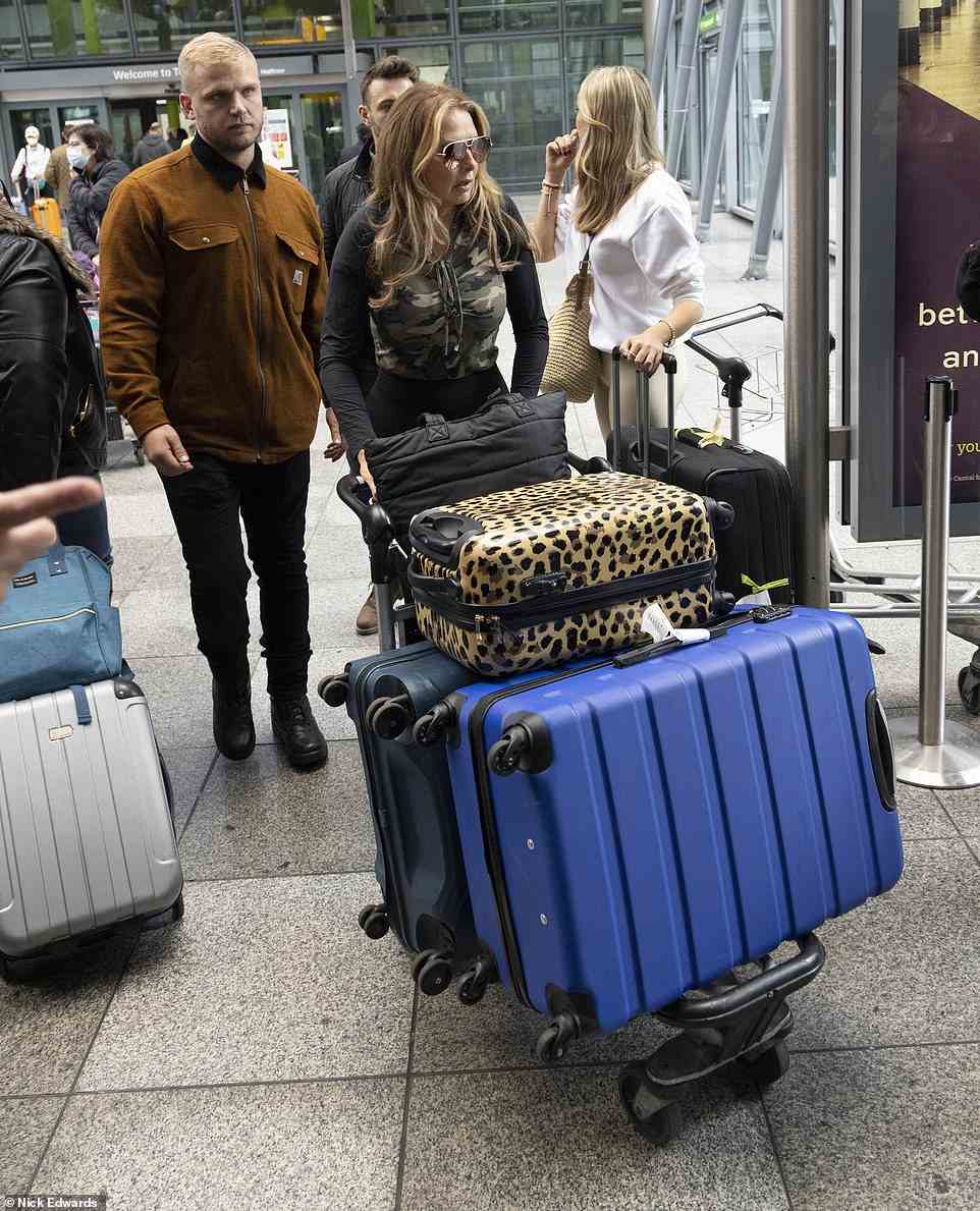 Heavy load: Carol had three huge suitcases on her carrier as she made her way home