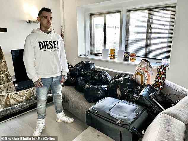 Tony Garnett at his Bradford home with his ex-girlfriend's luggage  and belongings in bin liners waiting to be collected