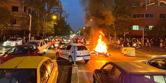 Ein Polizeimotorrad brennt während einer Protestaktion gegen den Tod einer jungen Frau, die am 19. September 2022 in der Innenstadt von Teheran, Iran, wegen Verstoßes gegen die konservative Kleiderordnung des Landes festgenommen worden war.