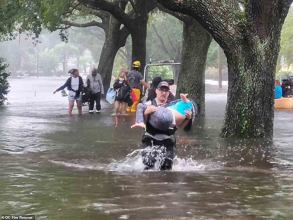 Good Samaritans are seen in Orange County trying to keep children from wading through the flash floodwater as Hurricane Ian continues to cross the state