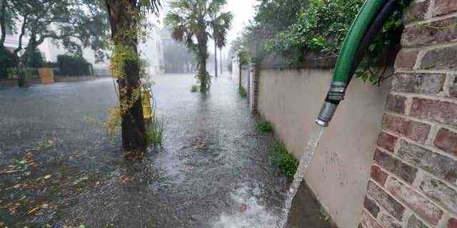 Die Bewohner verwenden Pumpen, um Wasser aus der Umgebung ihrer Häuser zu entfernen, da die Auswirkungen des Hurrikans Ian am 30. September 2022 in Charleston, South Carolina, zu spüren sind.