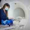 Dies zeigt einen Forscher, der ein Baby in einen MRT-Gehirnscanner legt