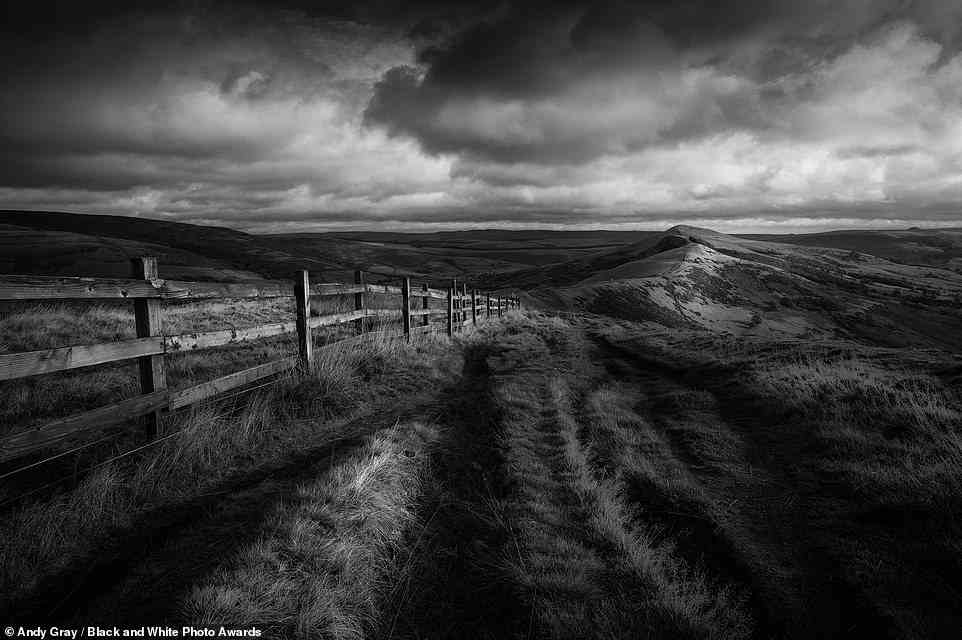 Diese beeindruckende Aufnahme von Andy Gray zeigt dunkle Wolken, die über den Great Ridge Walkway wirbeln, eine beliebte Wanderroute im Peak District, England.  Es erhält die „bronzene Erwähnung“ in der Kategorie „Landschaft“.