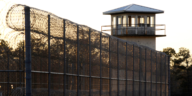 DATEI – Die Sonne geht am 27. Januar 2022 hinter dem Holman-Gefängnis in Atmore, Alabama unter.